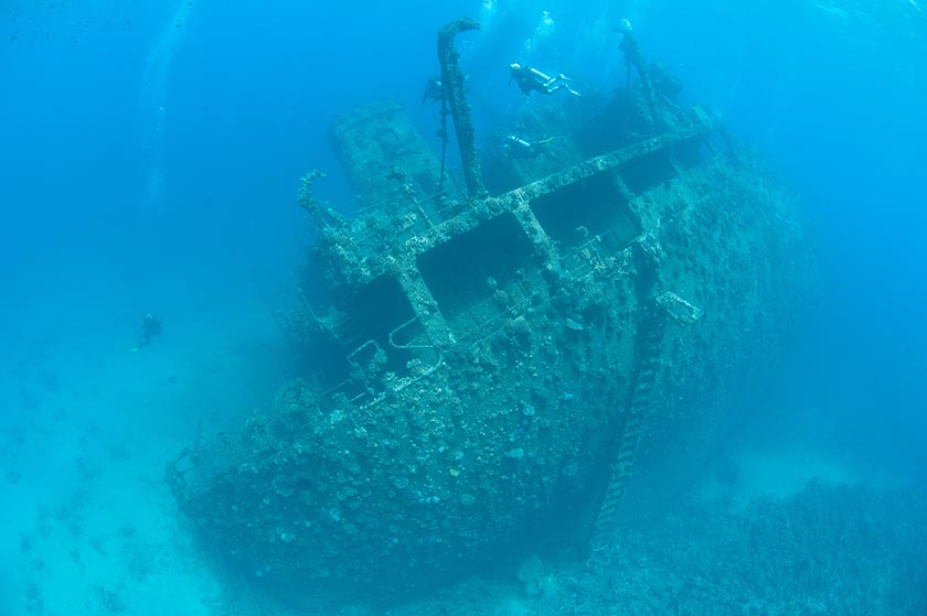深海里的沉船和潜水员特写摄影图片