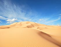 蓝天白云下的沙丘自然景观摄影图片