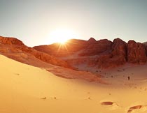 阳光下的山石沙漠脚印摄影图片