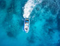 蔚蓝色海面上的快艇俯拍摄影图片