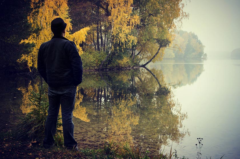 秋天站在湖边看风景的男人摄影图片