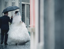正走在雨中的婚纱新娘高清图片
