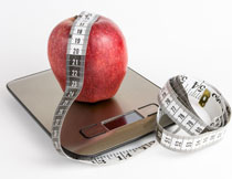 體重秤上的紅蘋果攝影高清圖片