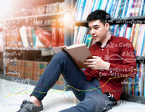 靠著書架看書的男學生高清圖片
